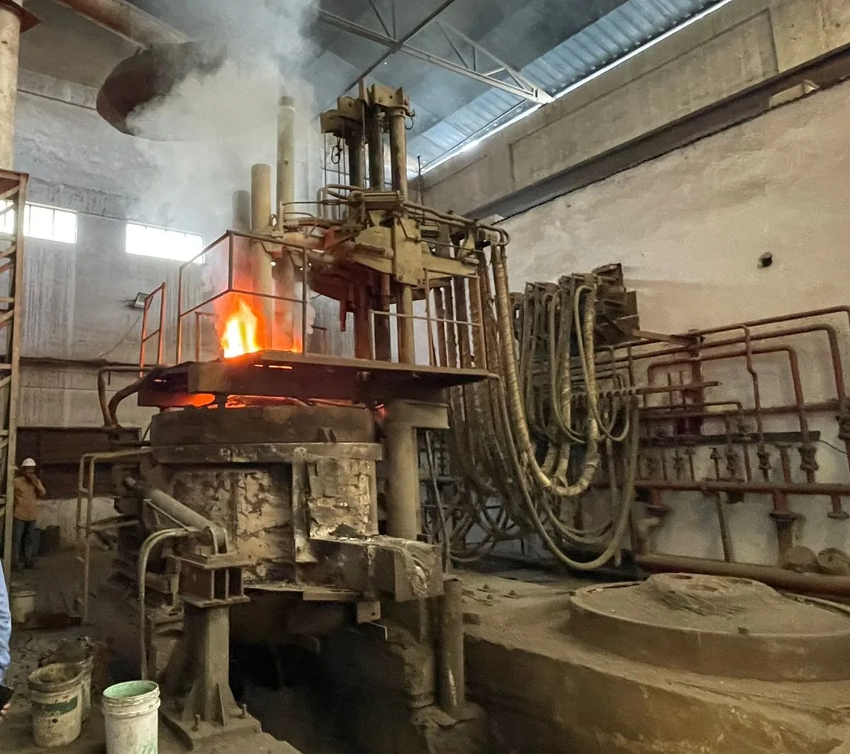 Electric arc furnace in operation with flame
