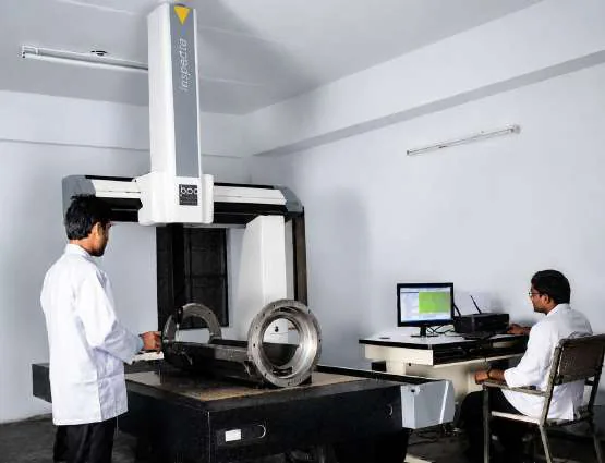 Engineers inspecting a component on a CMM